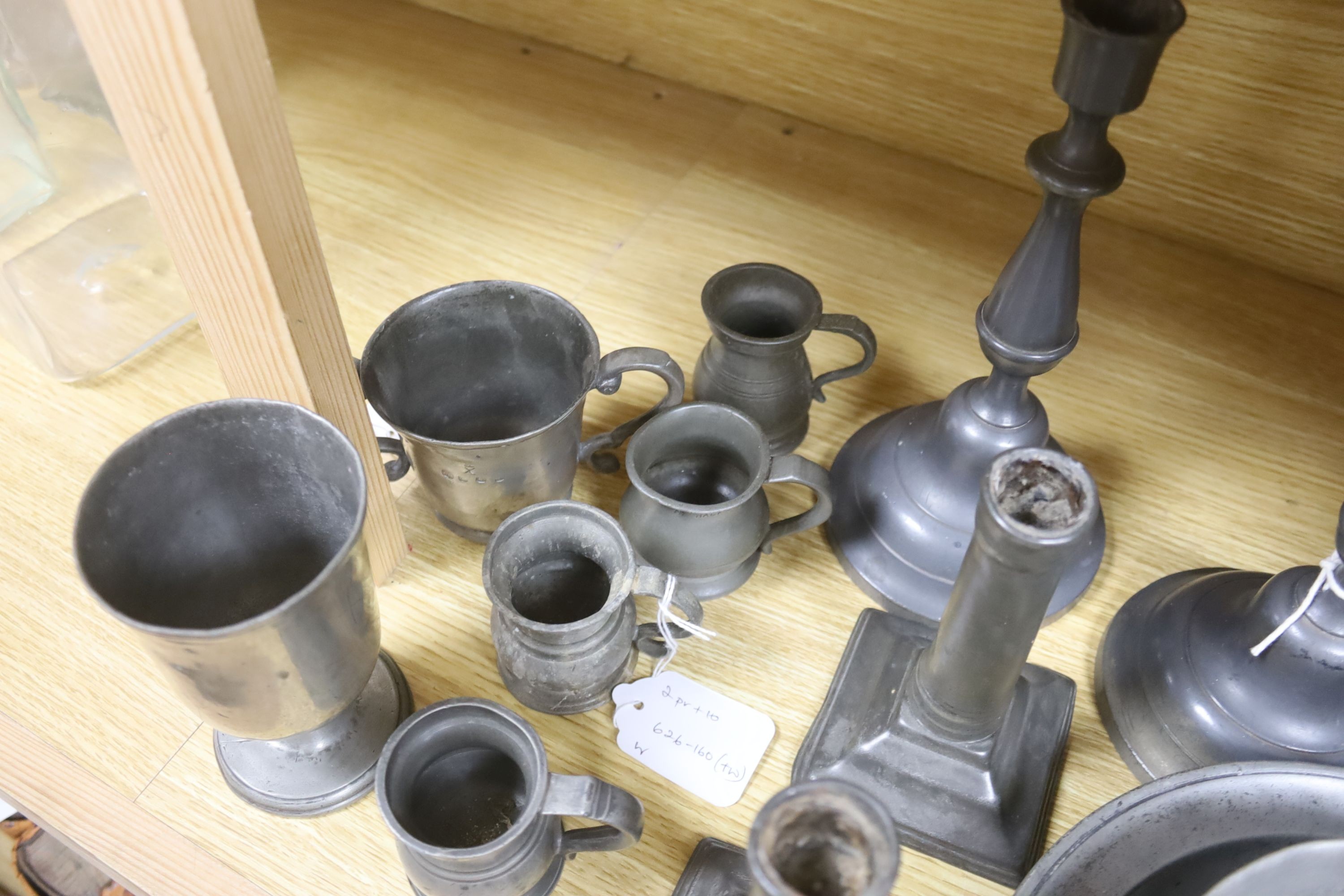 A French lidded pewter jug with double acorn thumbpiece, two pairs of pewter candlesticks and nine other items of pewter (14)